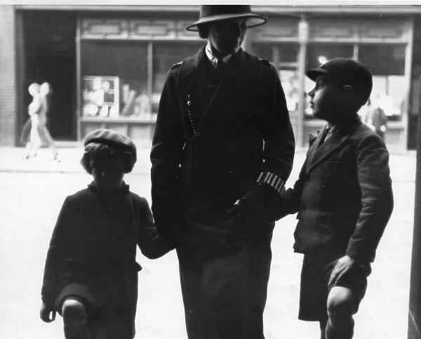 Woman police officer holding hands with children, London