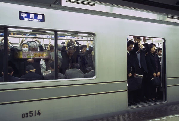 20049320. JAPAN Honshu Tokyo Subway train at a platform with passengers crowded on