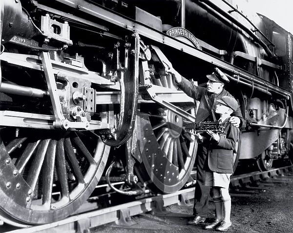 An engine driver explaining the valve gear to a schoolboy. This is the London Midland and Scottish
