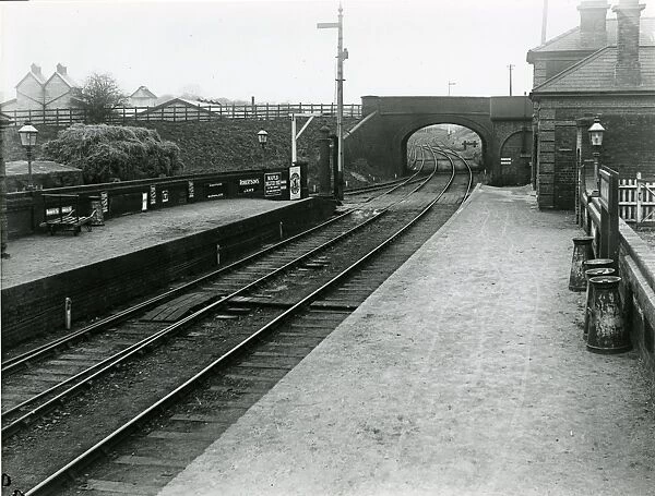 Looking west through road overbridge at Dunmow Station about 1911. Main (down side) buildings