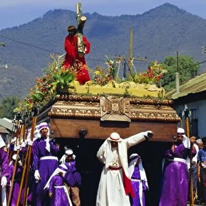 Men carry a huge wooden float of Christ over coloured