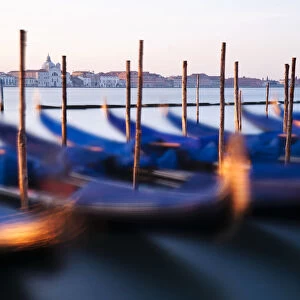 Traditional Venetian gondolas and mooring poles at dawn, Venice, Veneto region, Italy
