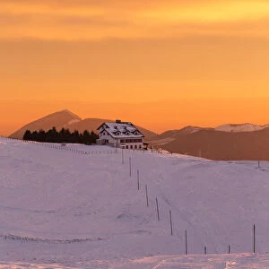 View of the Magnolini refuge during a winter sunset from Monte Pora, Val Seriana