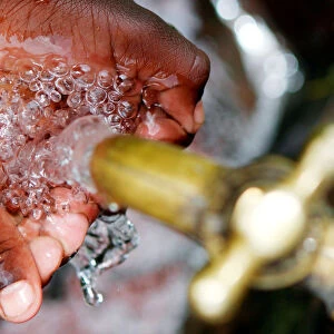 A child prepares to drink clean water from a tap in Kawangware district of Nairobi