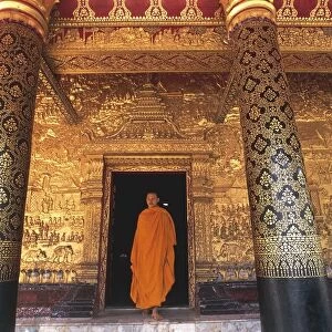 Laos, Luang-Phabang, Monk in doorway at Buddhist temple Wat Mai Suwannaphumaham