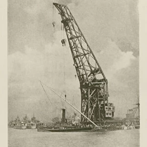 Giant floating crane being used to step the mast of King George Vs racing cutter Britannia (b / w photo)