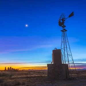 Crescent moon beside Mars and above Venus, framed by a windmill, New Mexico
