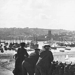 Three Cornish fishermen seen here in St Ives leaning on the harbour railings