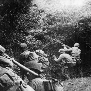 US infantrymen, fired at by an enemy German sniper, take to the ditch