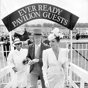 JOAN COLLINS AND HUSBAND PETER HOLM ARRIVING AT EPSOM RACECOURSE 01 / 06 / 1986