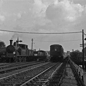 Southern Railways goods train passes a three carriage Electric Multiple Unit train on a